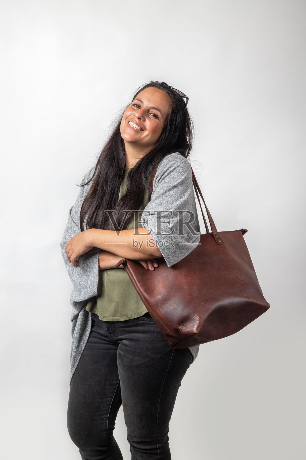 长发微笑的西班牙裔女性，背景明亮，摄影棚拍摄照片摄影图片