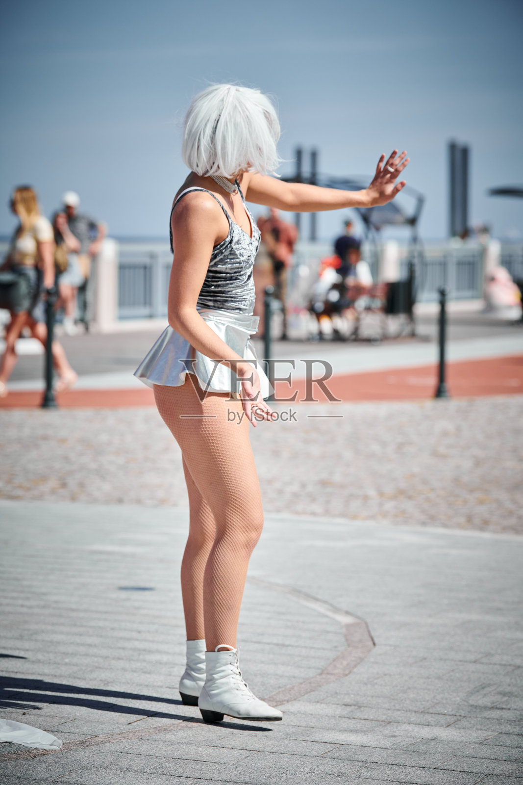 年轻性感女孩在太空中穿着银色微型裙，优雅而柔和地舞动。照片摄影图片