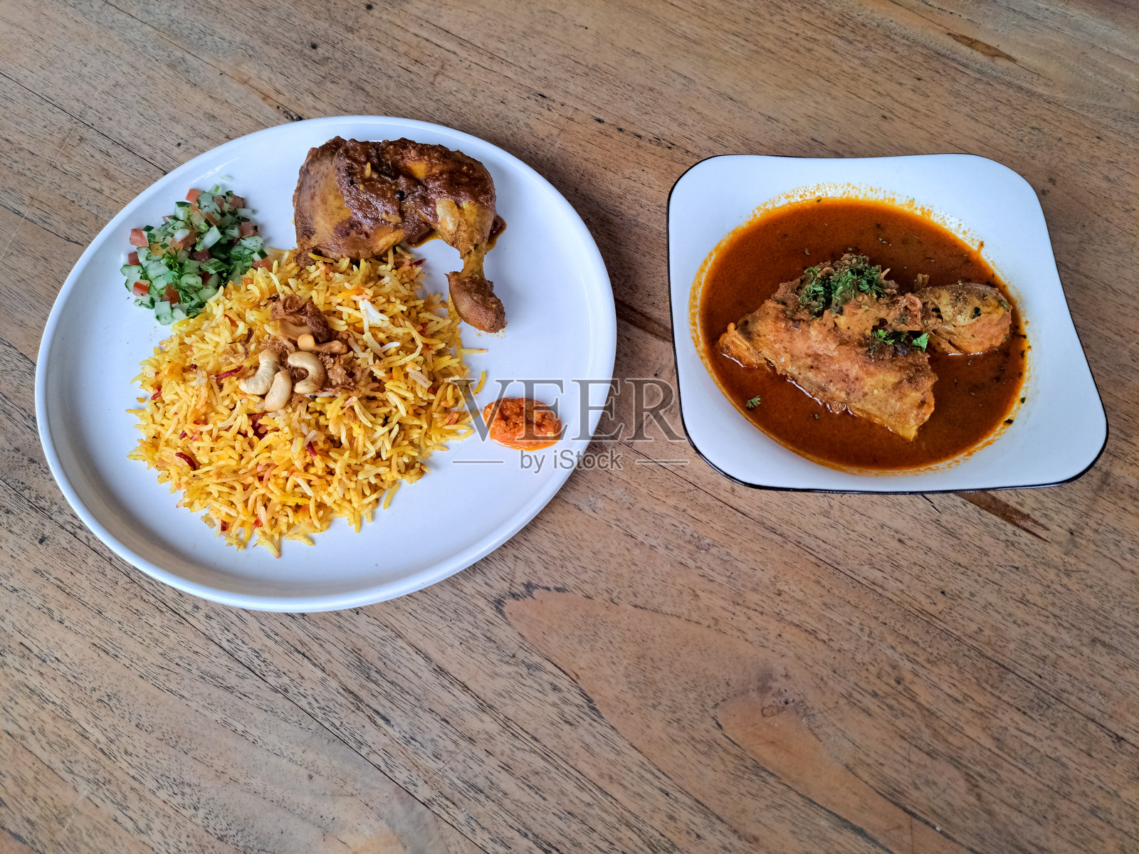 美味的鸡肉香饭，配有炸洋葱、腌制品、腰果和辣椒酱。鸡肉咖喱，包含鸡胸肉和鸡腿。中东美食菜单。照片摄影图片