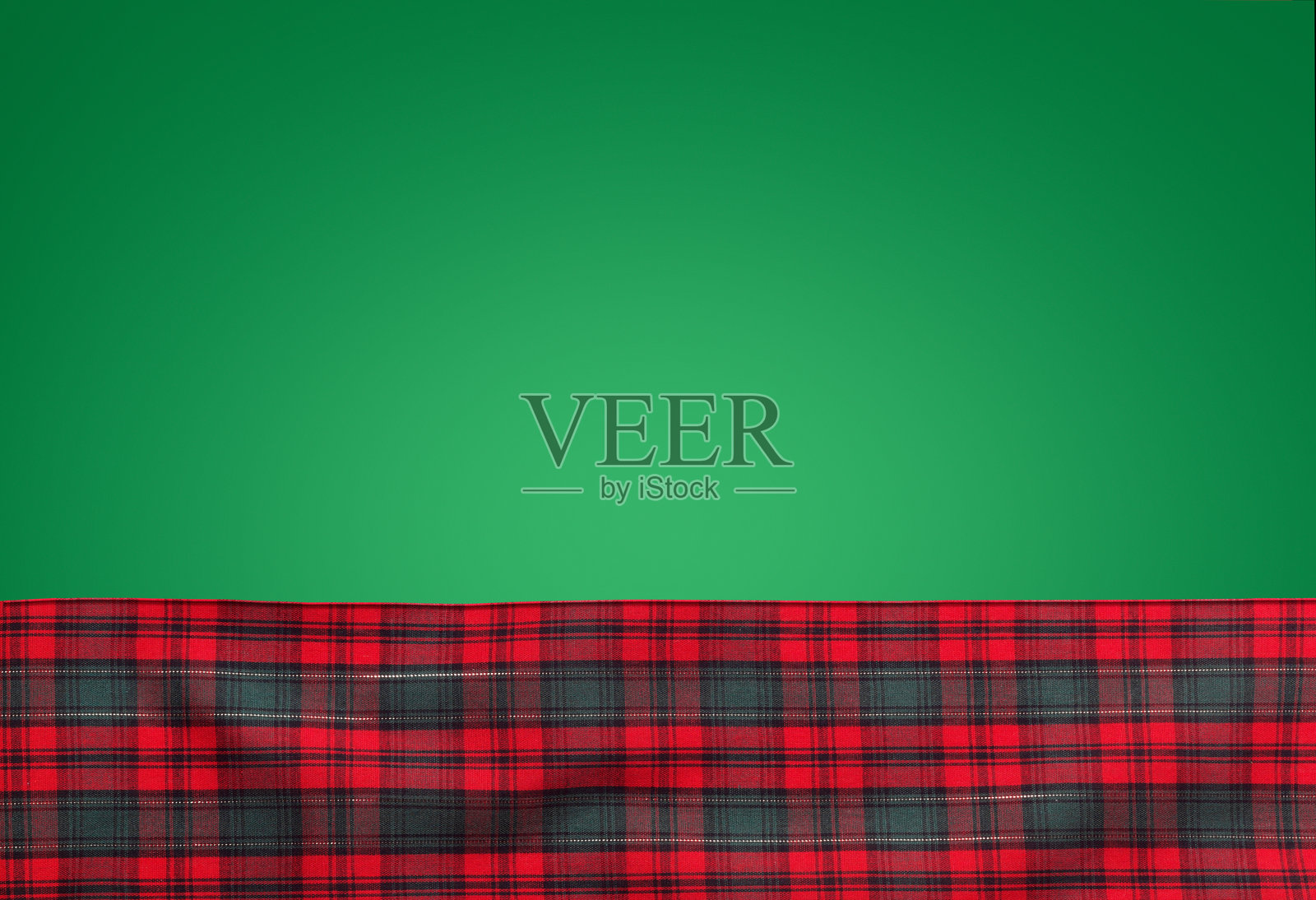 绿色背景上的红色格子布料照片摄影图片