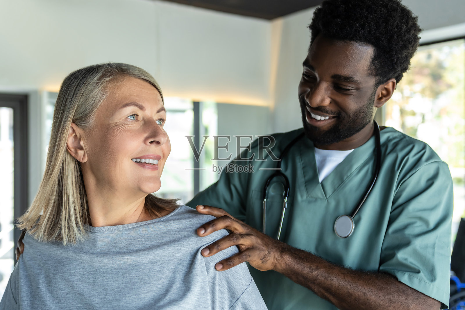 非裔美国男性医生正在纠正女性患者的姿势照片摄影图片