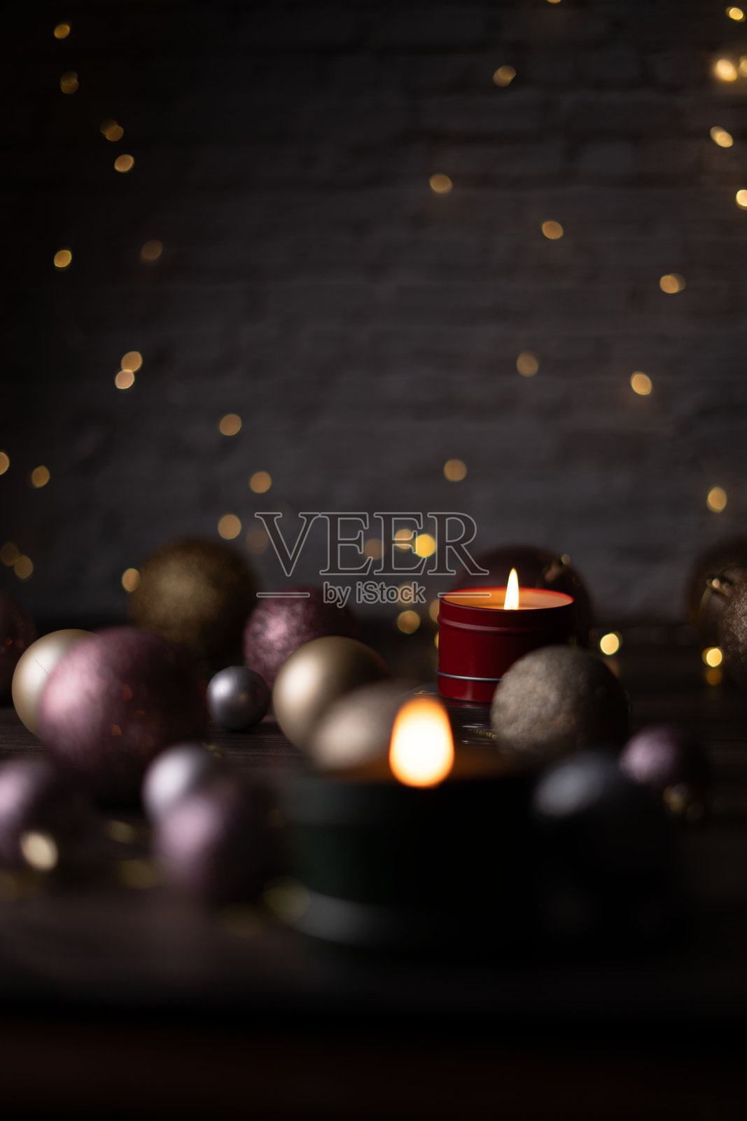 优雅的节日场景，柔和的烛光映衬着温暖舒适的氛围，点缀着精致的装饰球和梦幻的散景背景。照片摄影图片