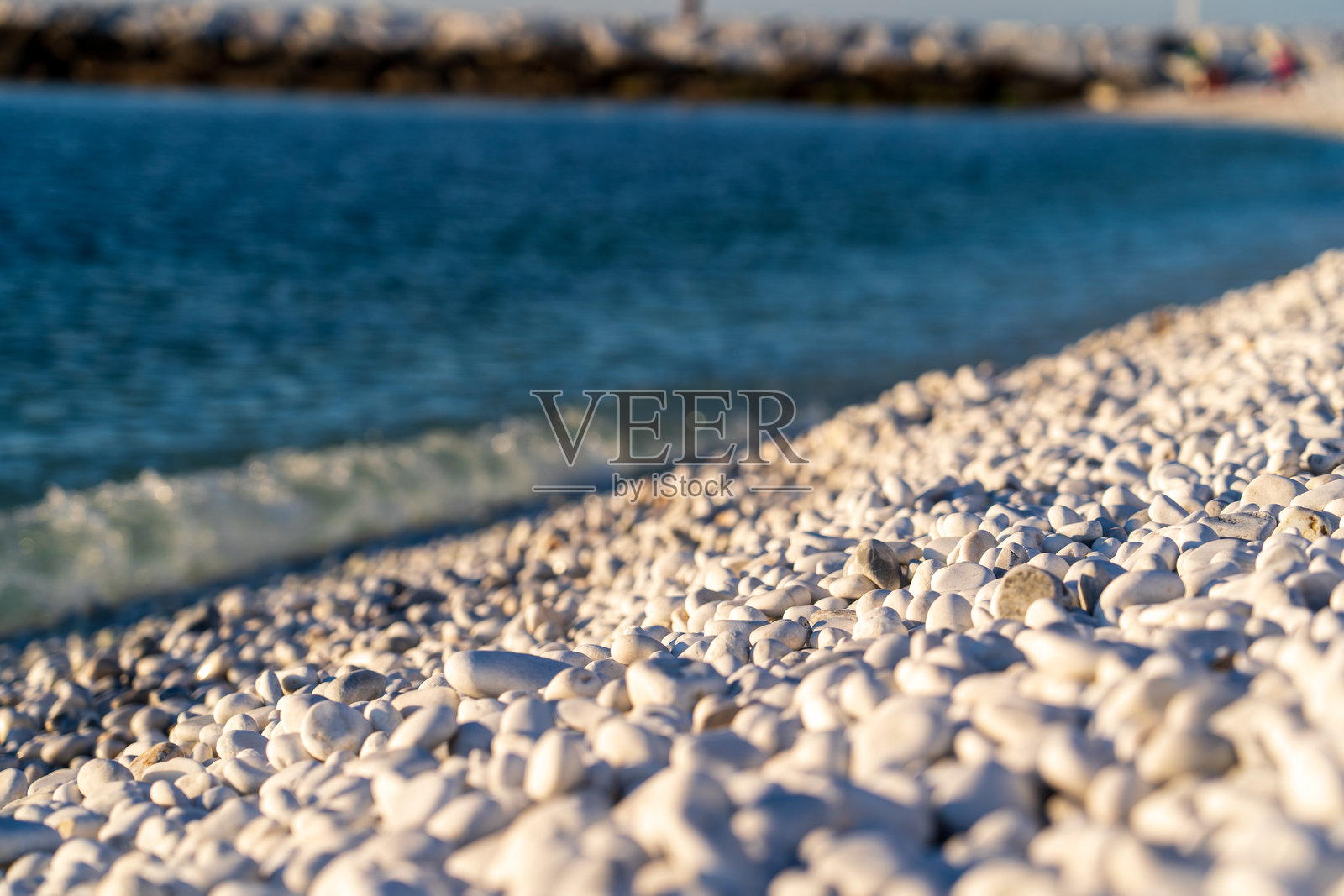 意大利比萨海港，2024年11月4日：海滩上雪白的石头景观。白色石子。照片摄影图片
