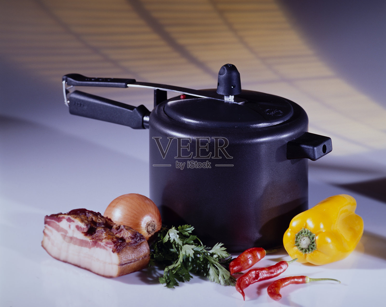 黑色压力锅、胡椒、洋葱、培根和调味品照片摄影图片