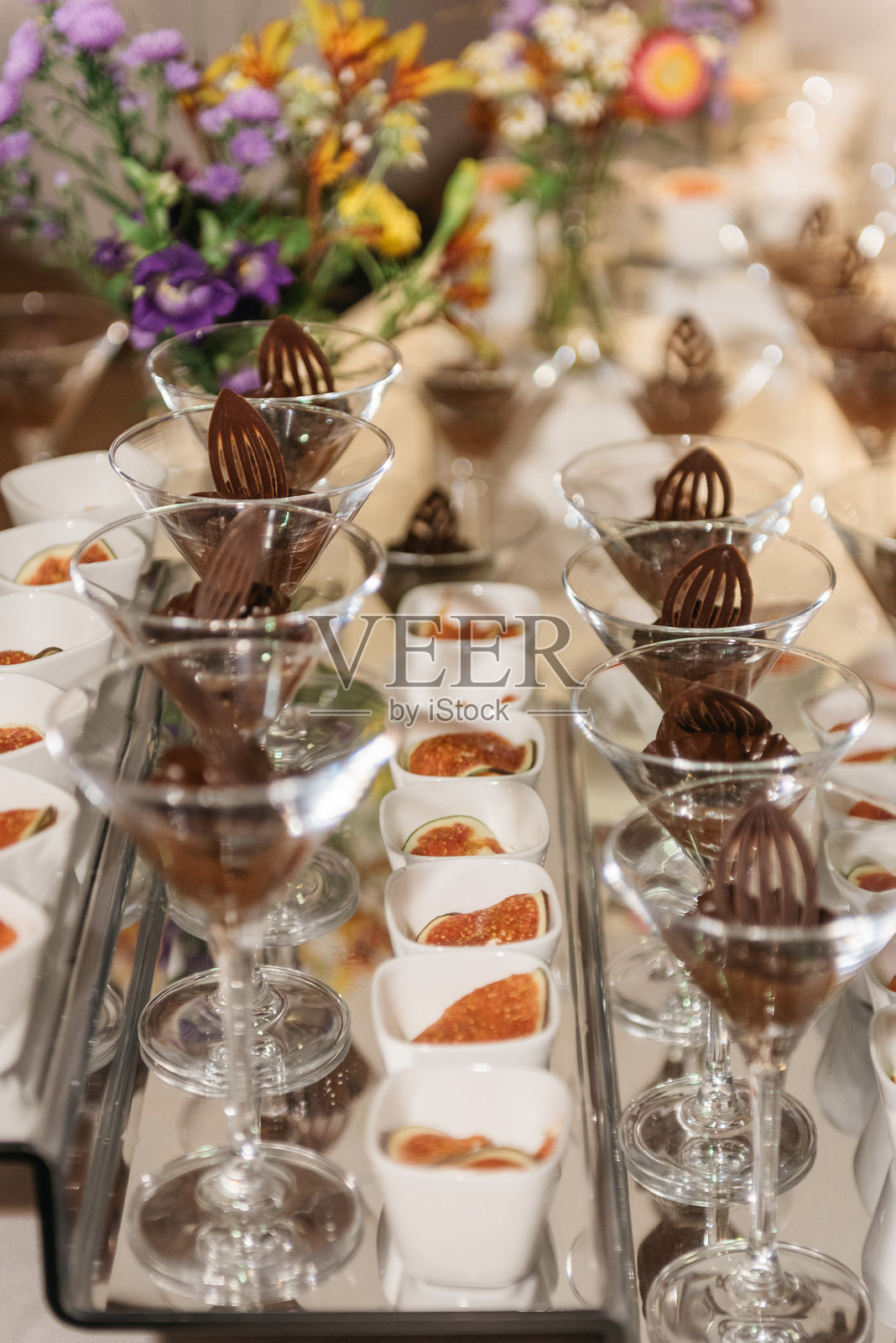 婚礼接待上的优雅甜点展示，配有巧克力慕斯和野花照片摄影图片