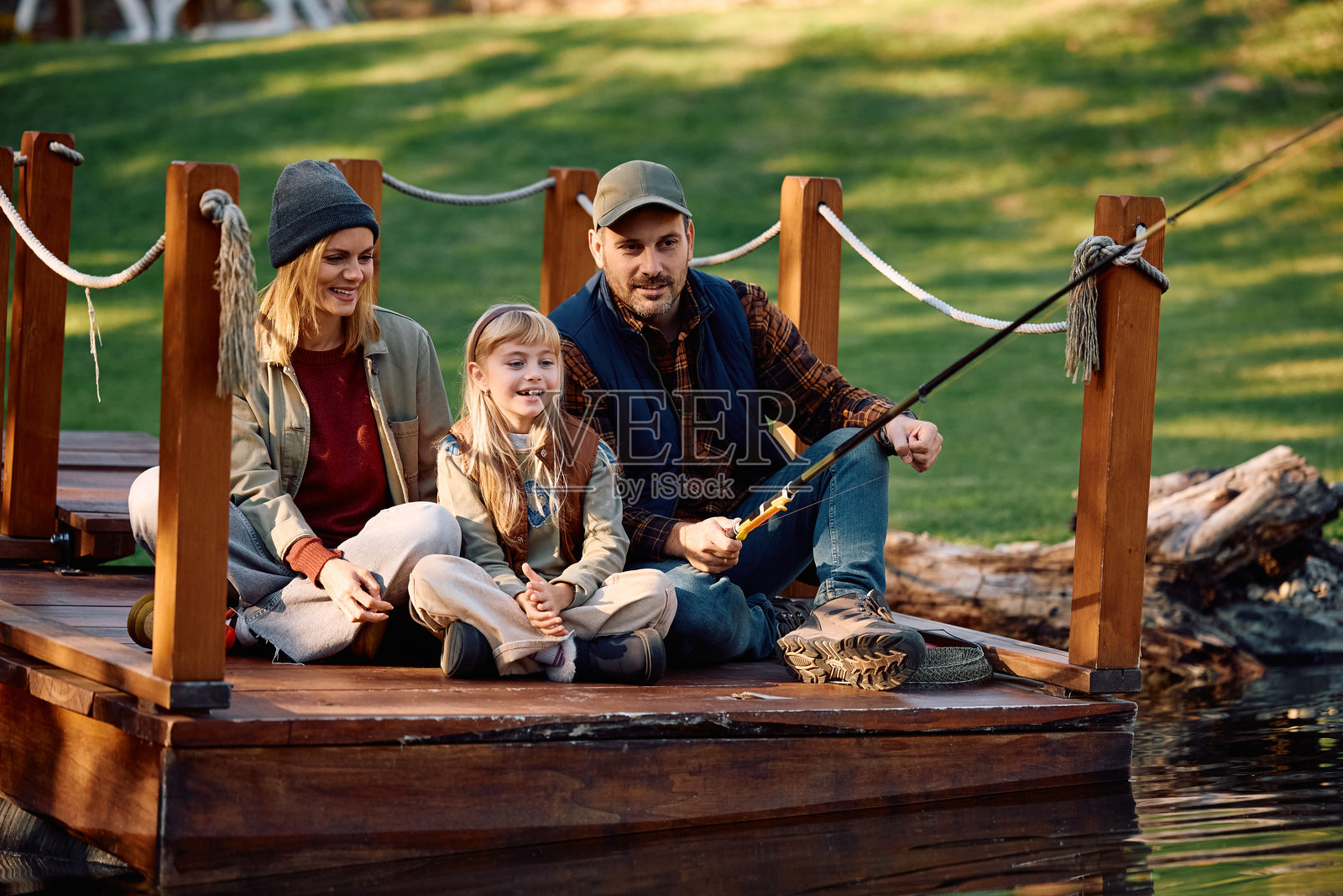 快乐的男人和家人在湖边钓鱼。照片摄影图片