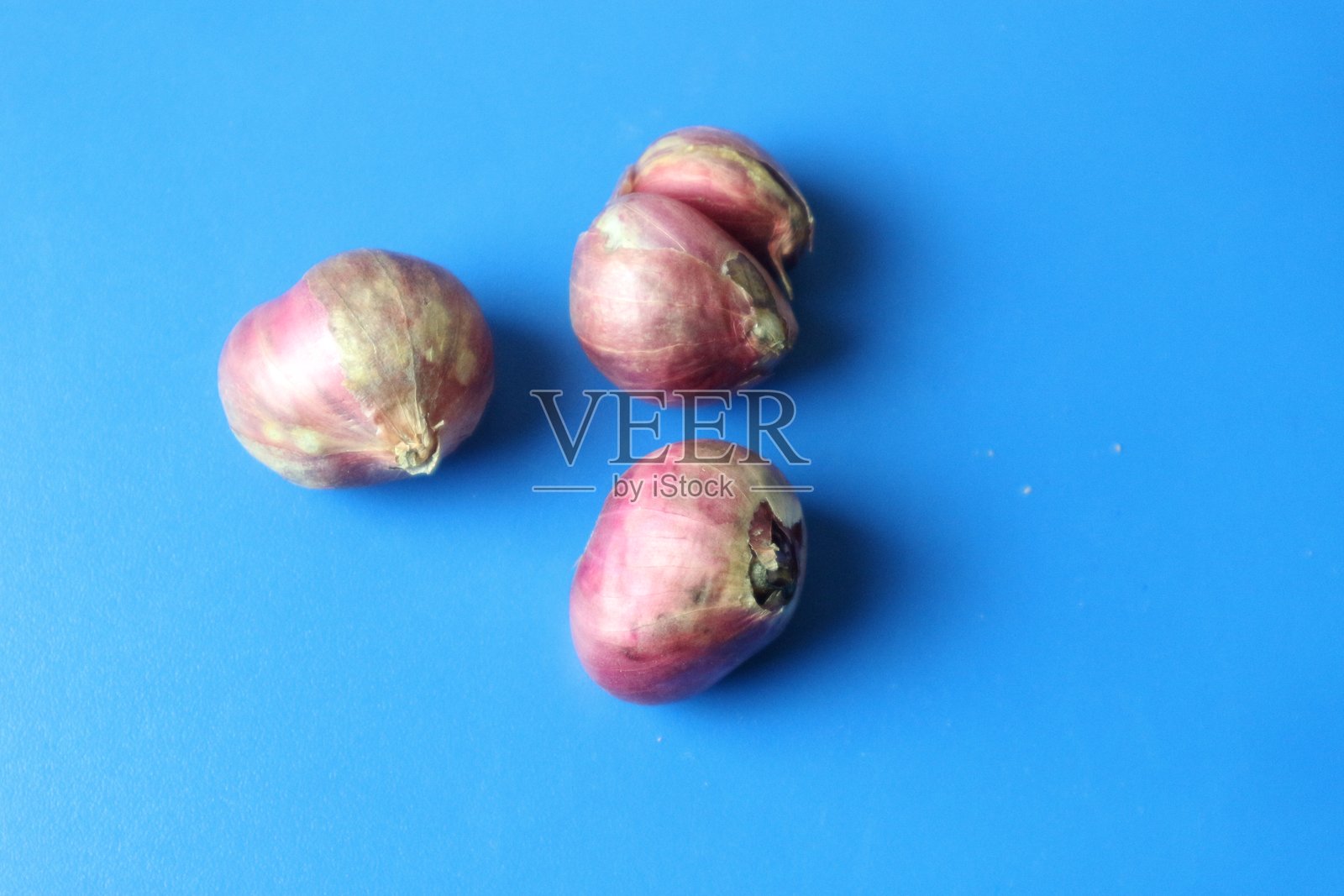 新鲜的红洋葱在蓝色背景上照片摄影图片