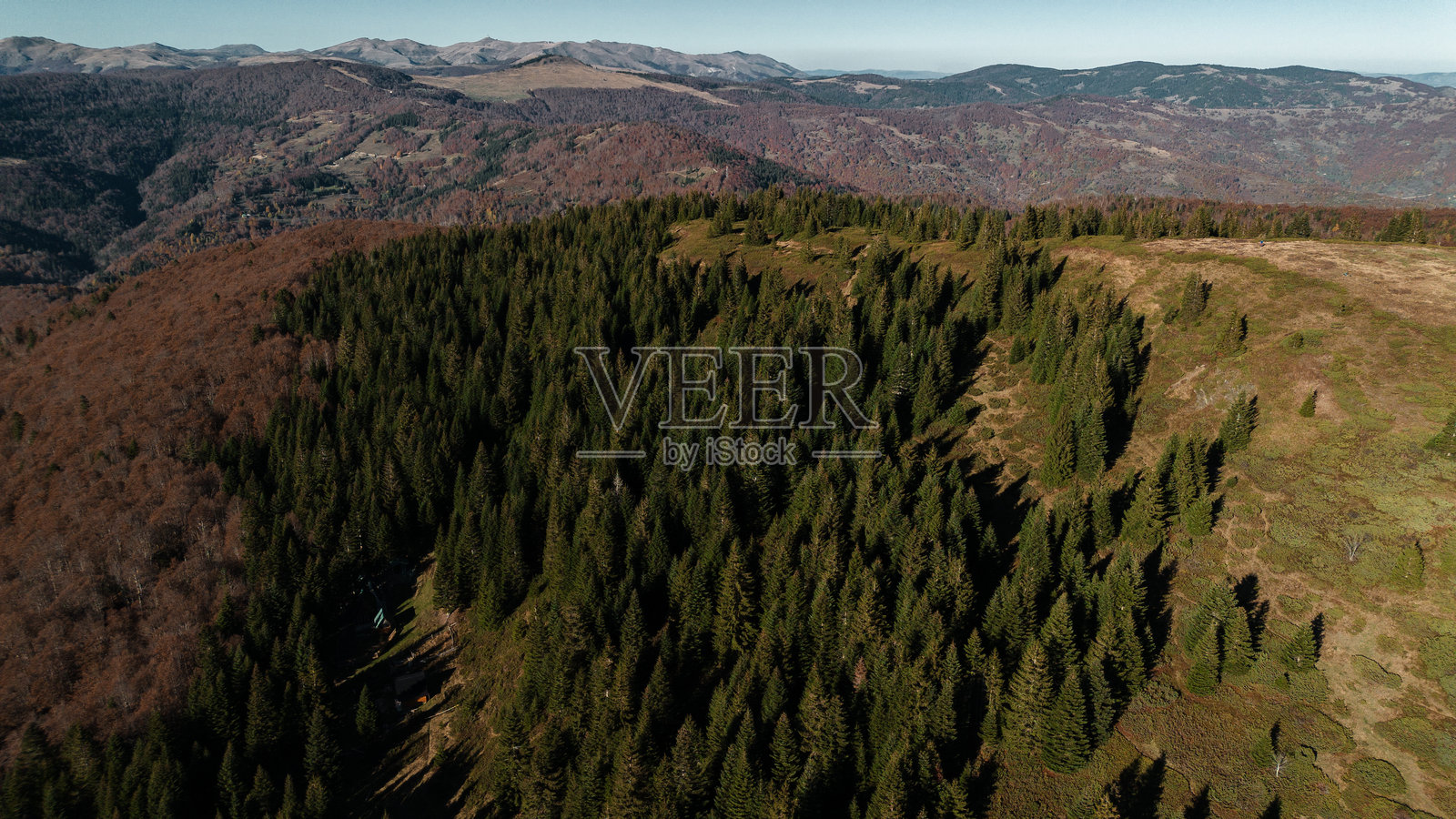 黑山科莫维山谷的航拍图，蓝天下的秋季美景。壮丽的山脉风光，金色的森林与远处的山脊相映成趣。照片摄影图片