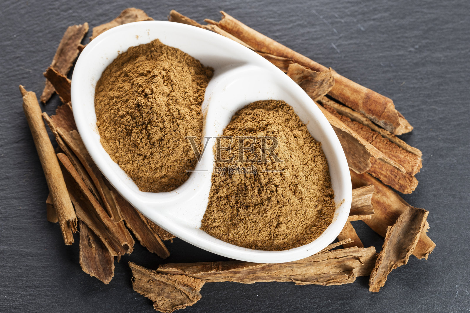 石板上的肉桂棒和磨碎的香料照片摄影图片