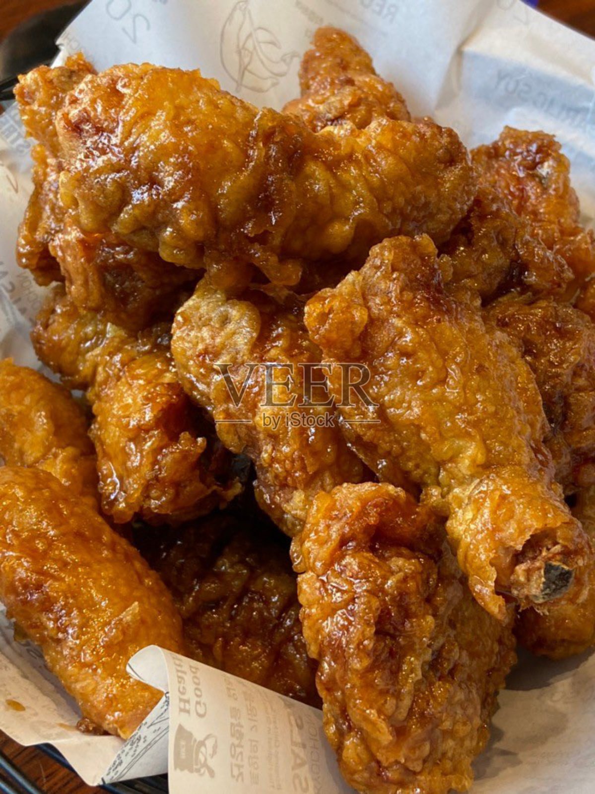 酥脆的韩国炸鸡，完美地裹上甜辣酱。非常适合食品摄影和菜单，展现这道受欢迎菜肴的不可抗拒的脆感和风味。照片摄影图片