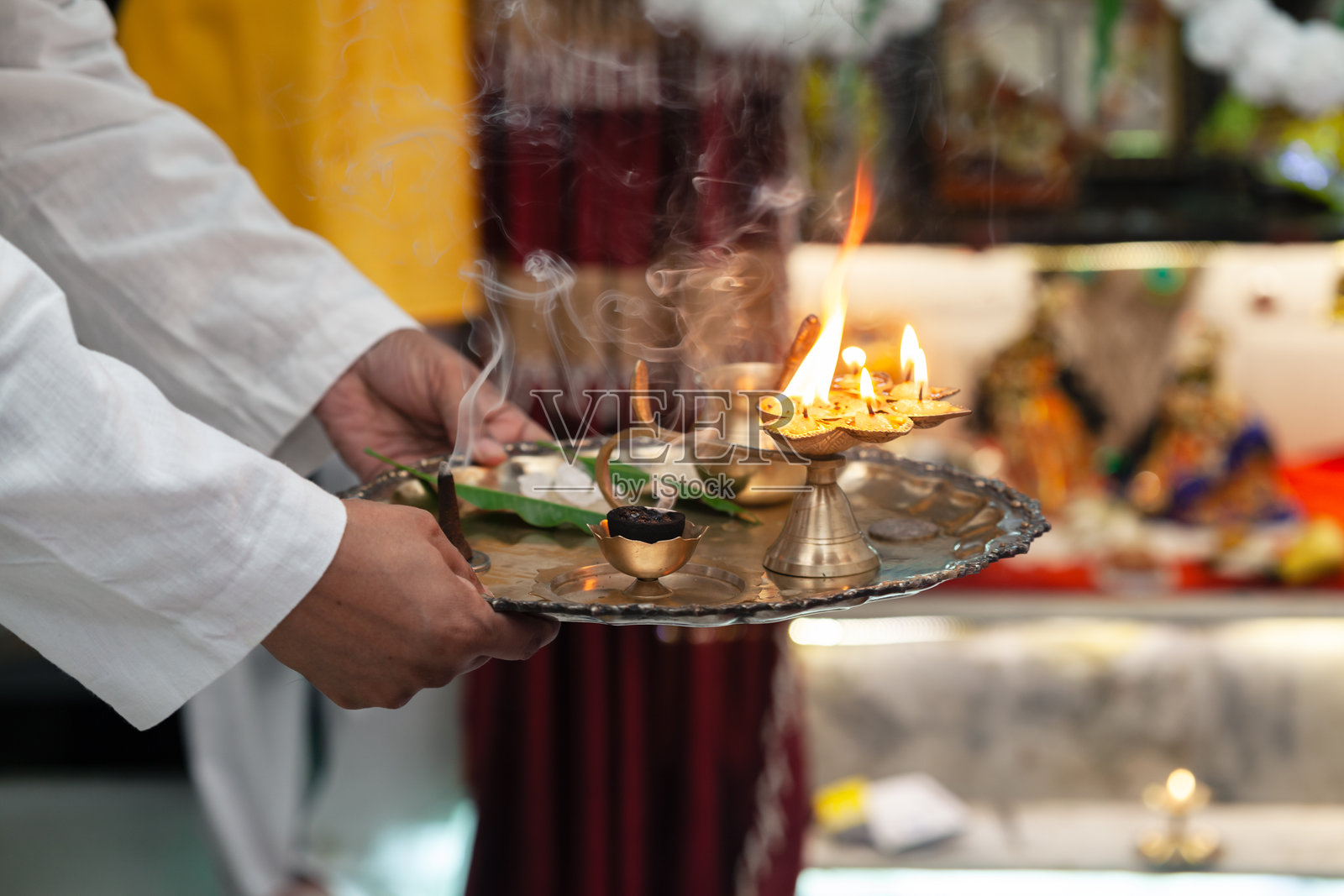 一位印度男子准备在印度教的祭祀仪式背景下进行点灯仪式。照片摄影图片
