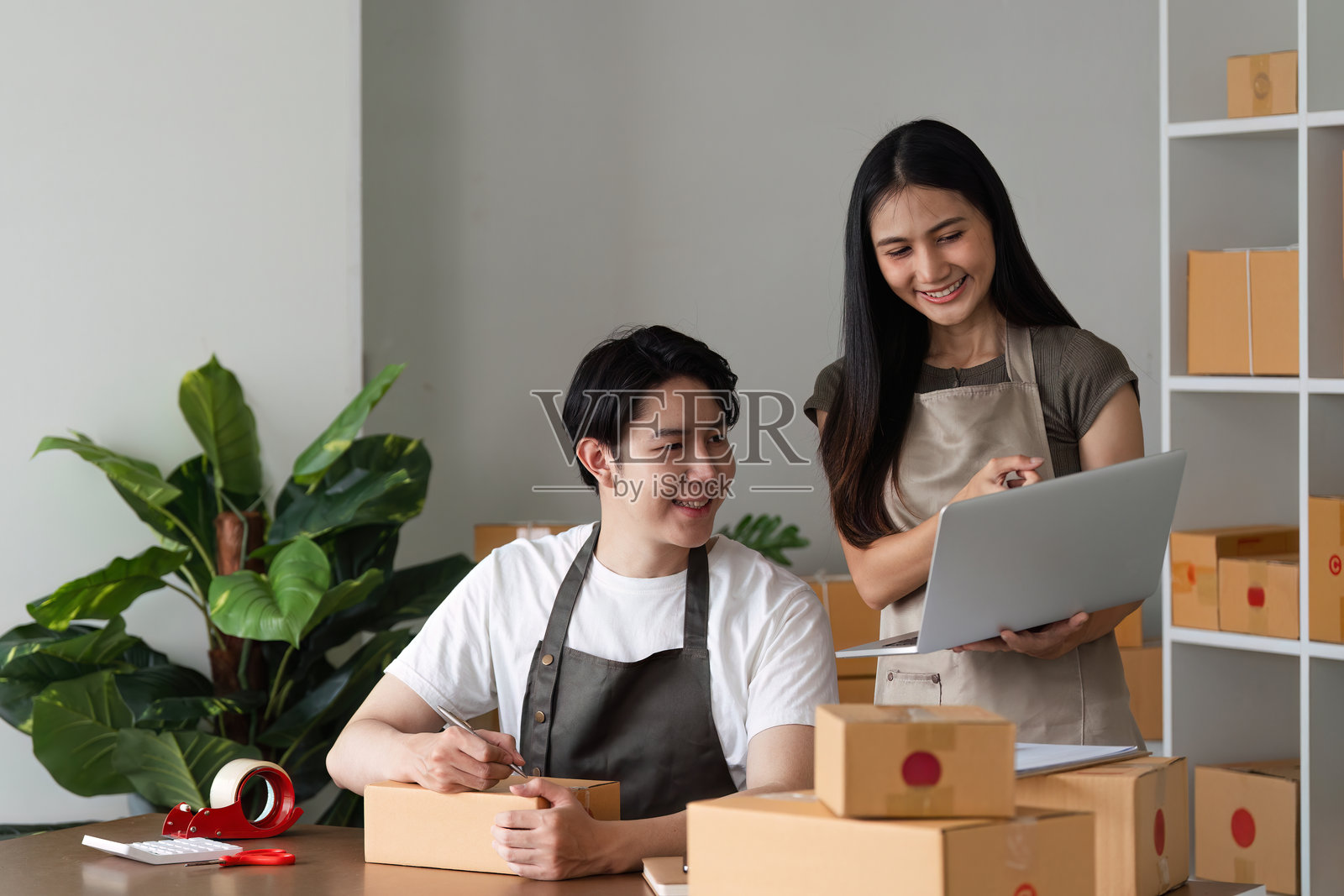 夫妻在家办公环境中管理在线业务库存并检查产品库存。照片摄影图片