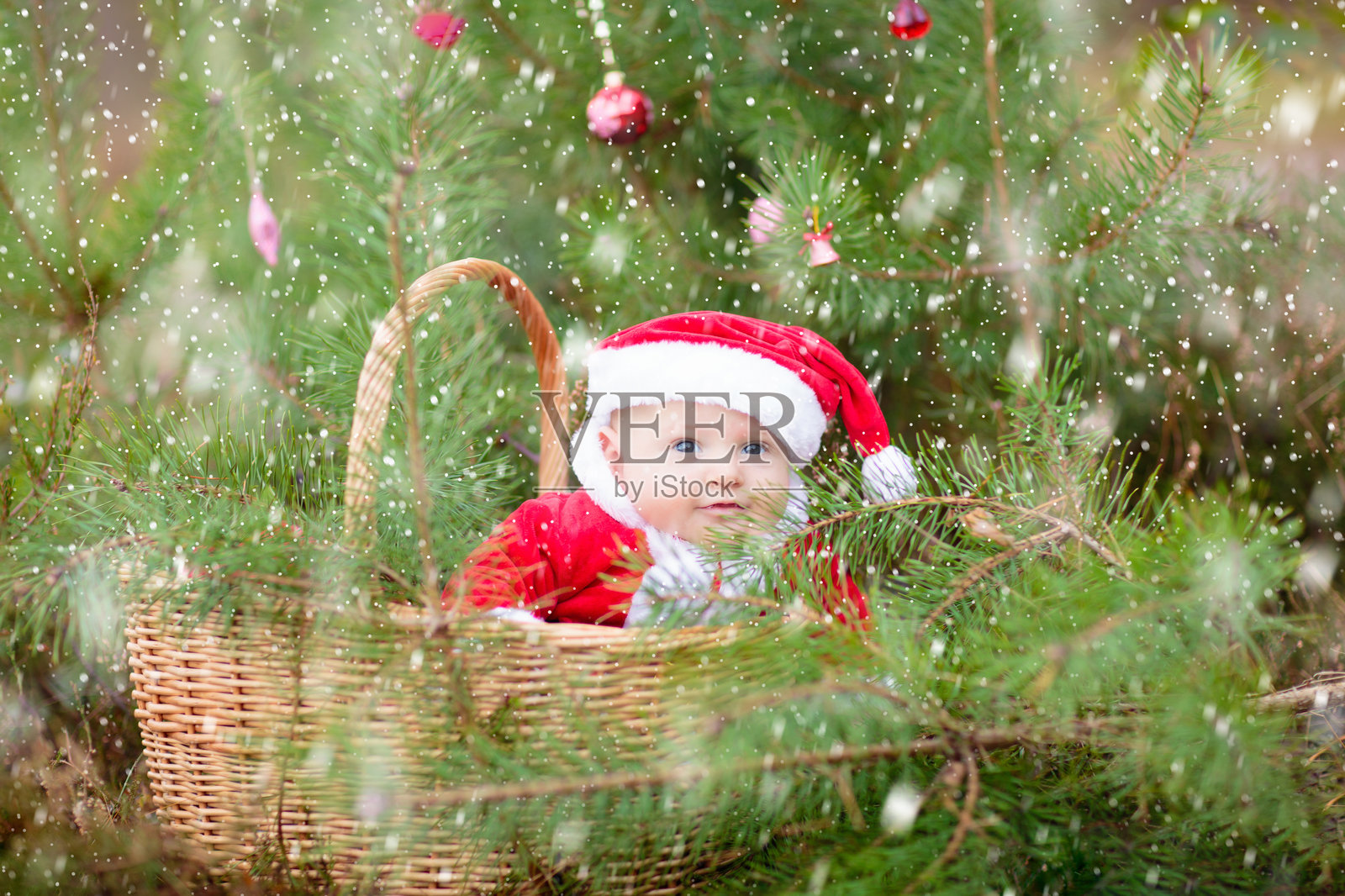 圣诞树下穿着圣诞老人服装的宝宝照片摄影图片