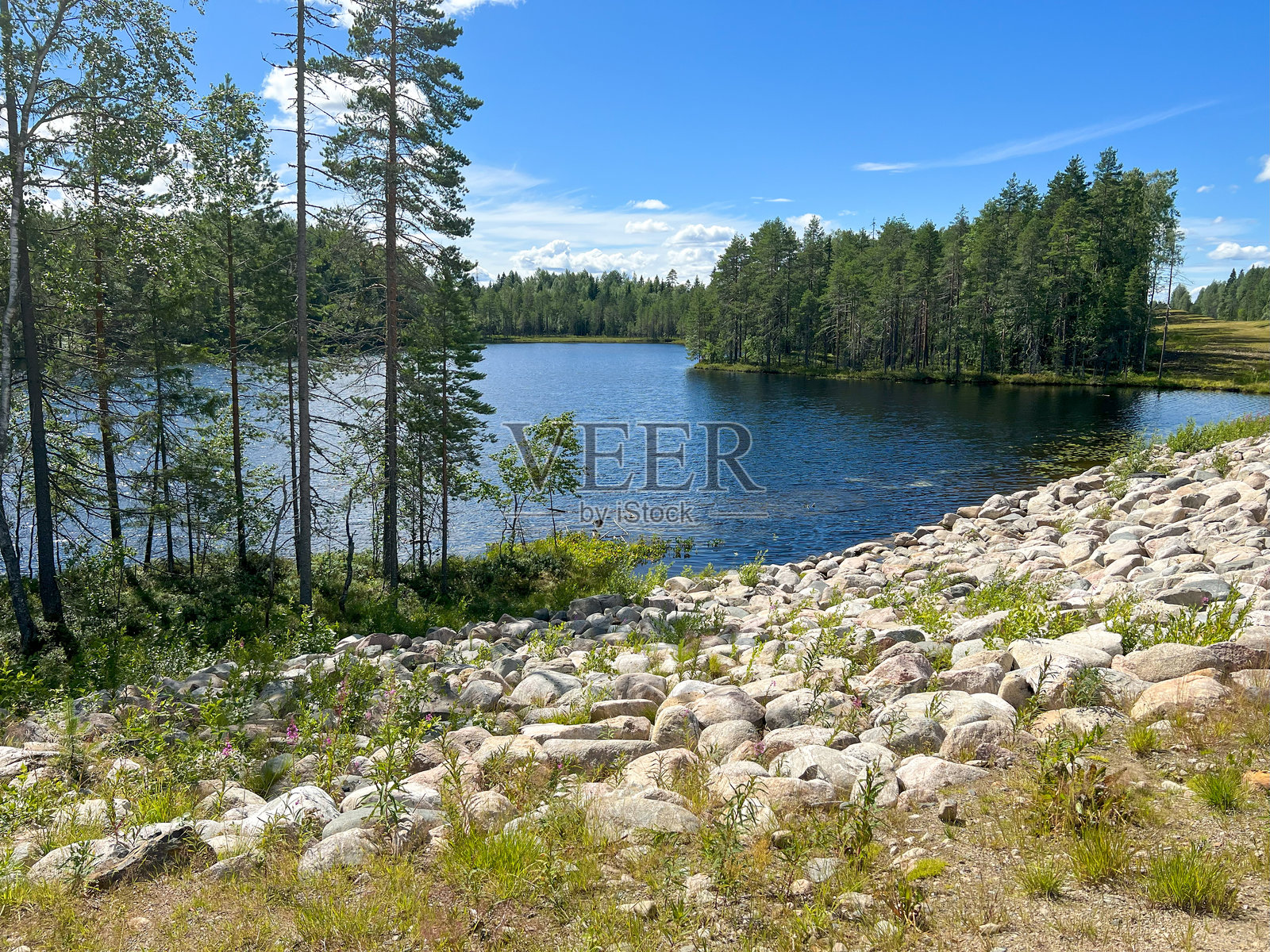 一片广阔的水域被树木和岩石美丽地环绕着照片摄影图片