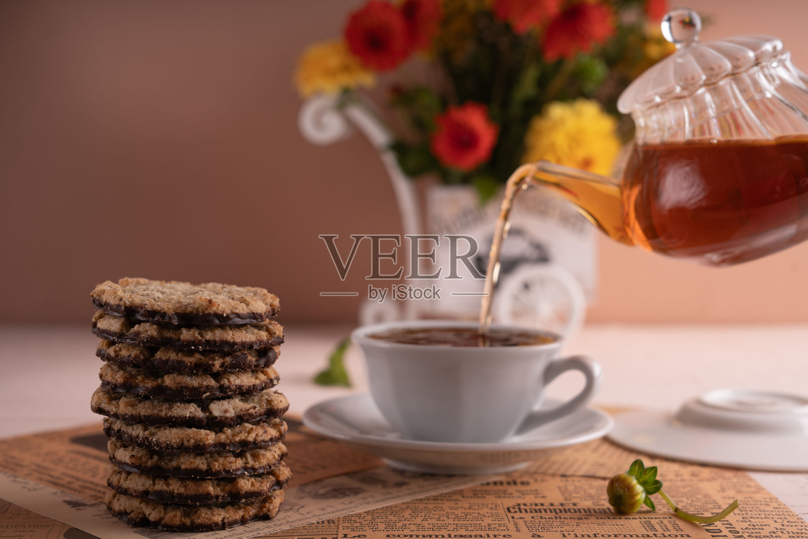 放松的茶时间体验，搭配花卉花束，优雅的瓷茶壶，芳香的草本茶，香甜的饼干，精致的装饰和美味的摆设。照片摄影图片