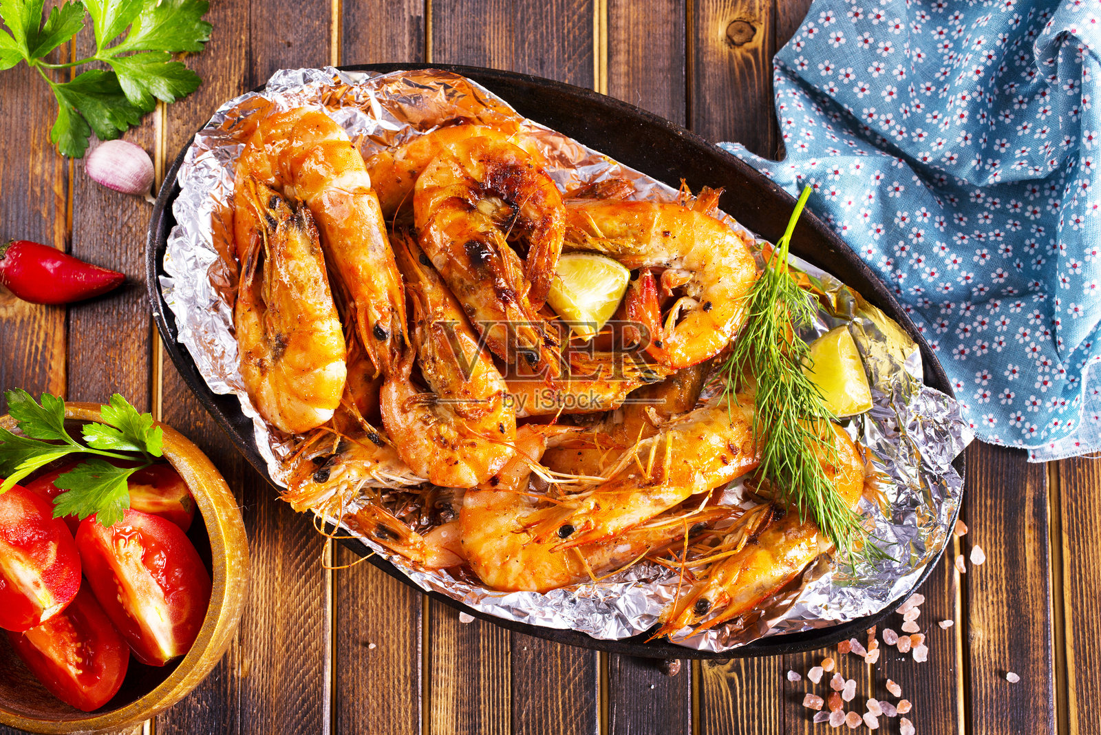 香草大蒜煎虾仁，背景为深色木材。照片摄影图片