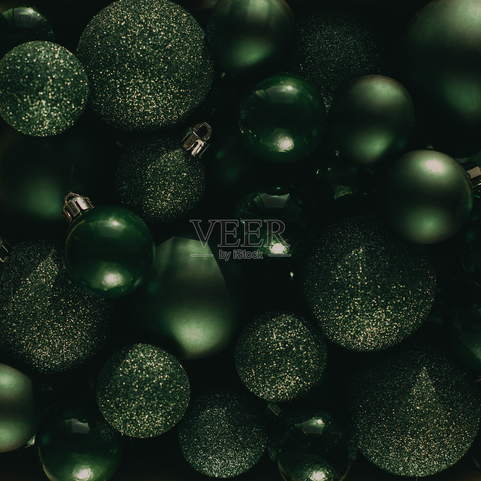 平铺的绿色圣诞球堆，大小和质地各异，闪闪发光，仿佛在模仿圣诞树。新年装饰，节日布置。照片摄影图片