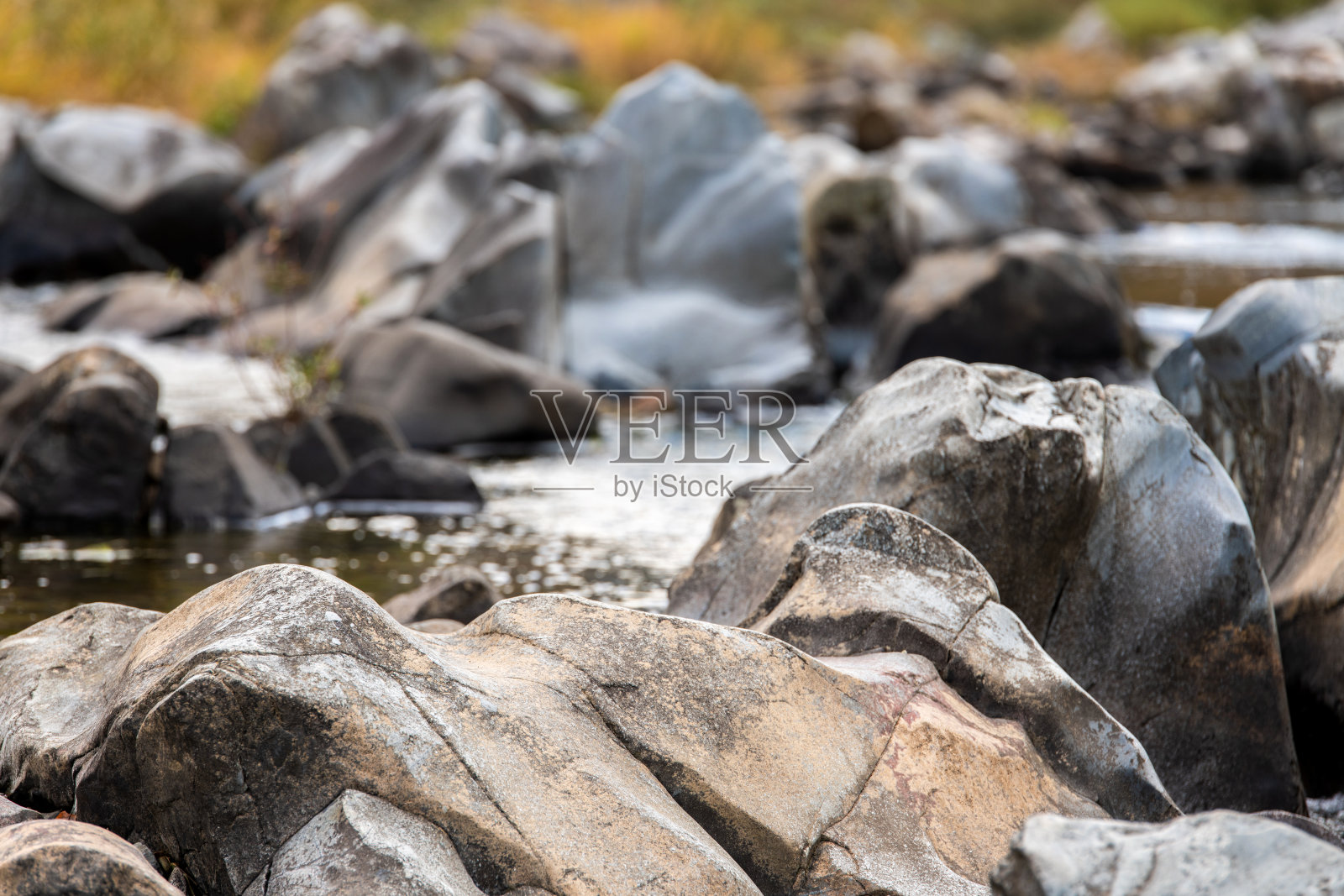 秋天溪流中的岩石和流动的水照片摄影图片
