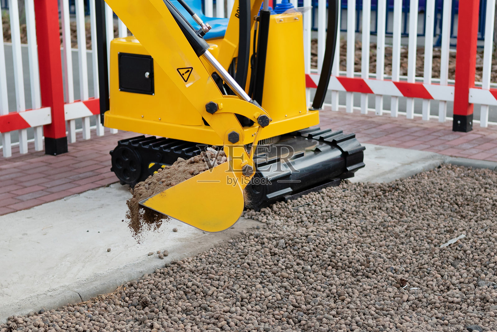 施工现场的小型挖掘机。用于土方工程的紧凑型施工设备。照片摄影图片