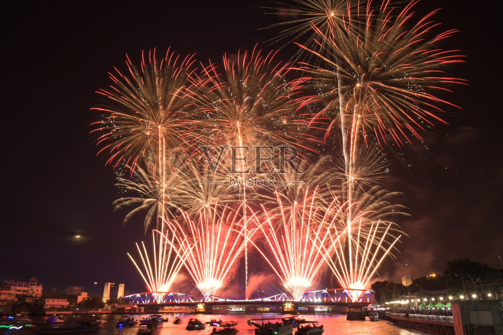 人们在纪念桥上欣赏湄南河的烟花表演。照片摄影图片