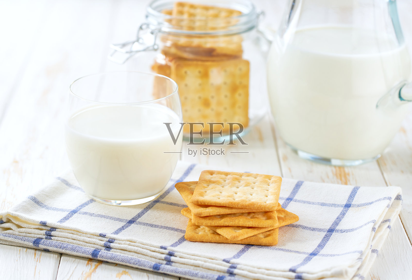 轻便的厨房桌上摆放着小麦饼干和一壶新鲜牛奶，健康的早餐。照片摄影图片