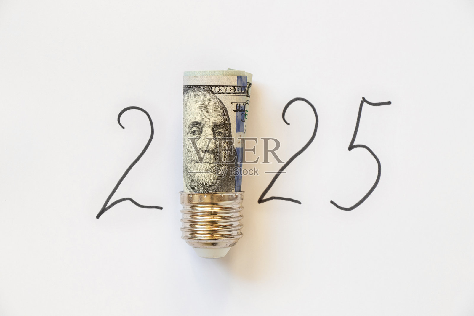 一个灯泡插座里放着一百美元，背景是白色，上面有“2025”的文字，象征着金钱与光明。照片摄影图片