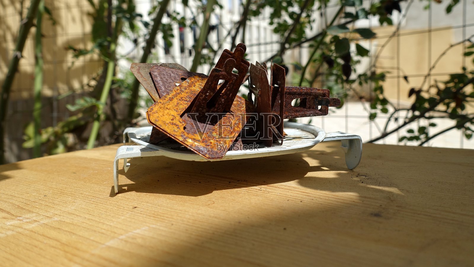 一组生锈的蚊香架放在花园的桌子上。照片摄影图片