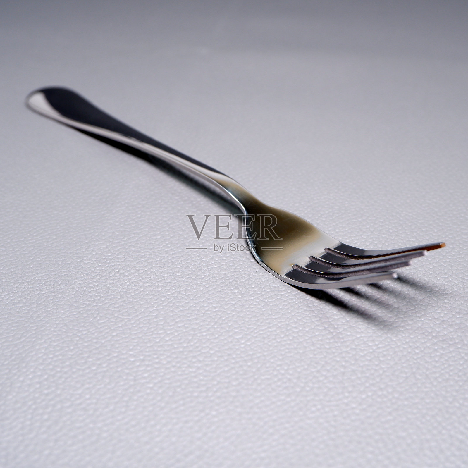 银色叉子在灰色背景上孤立的特写视图，叉子微距摄影概念照片摄影图片
