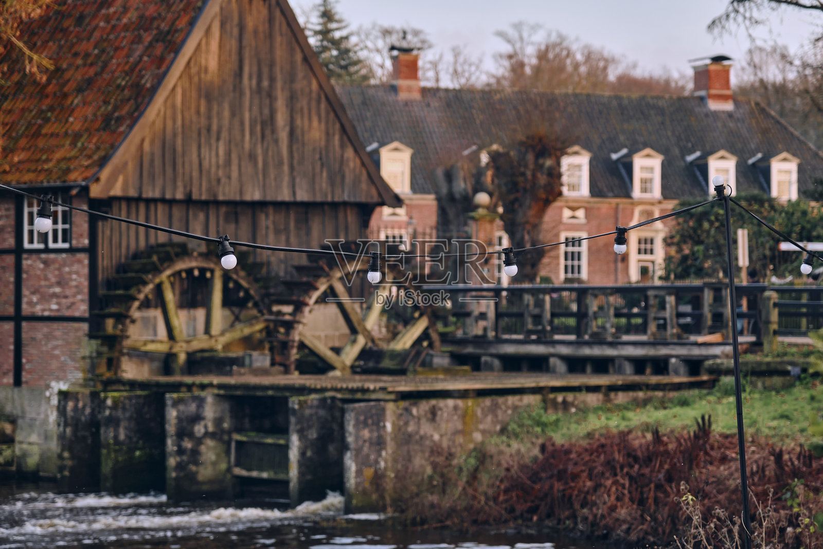 德国拉格的历史水车，配有木轮和传统建筑风格。照片摄影图片