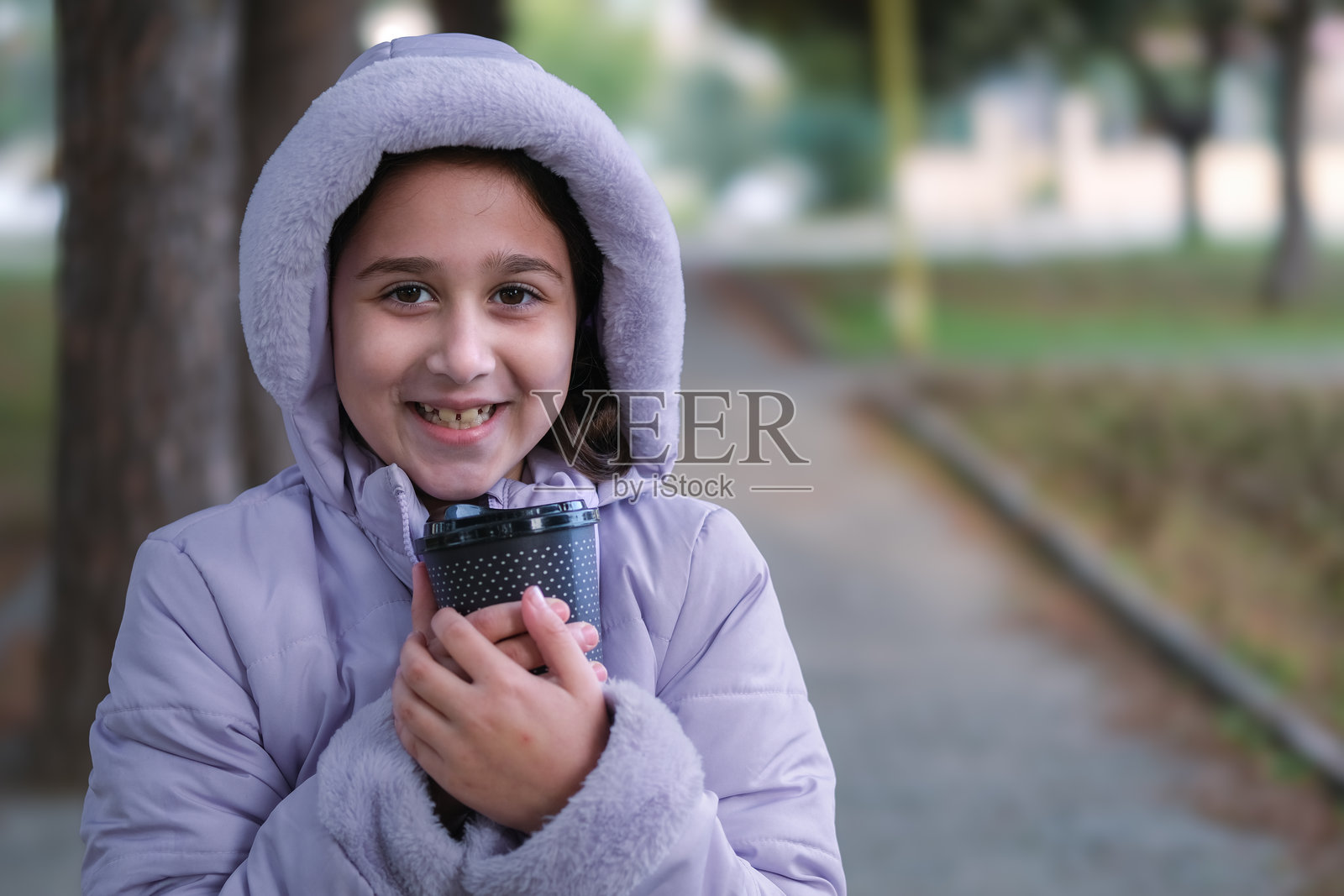 美丽的女孩在寒冷的冬天喝热巧克力。照片摄影图片