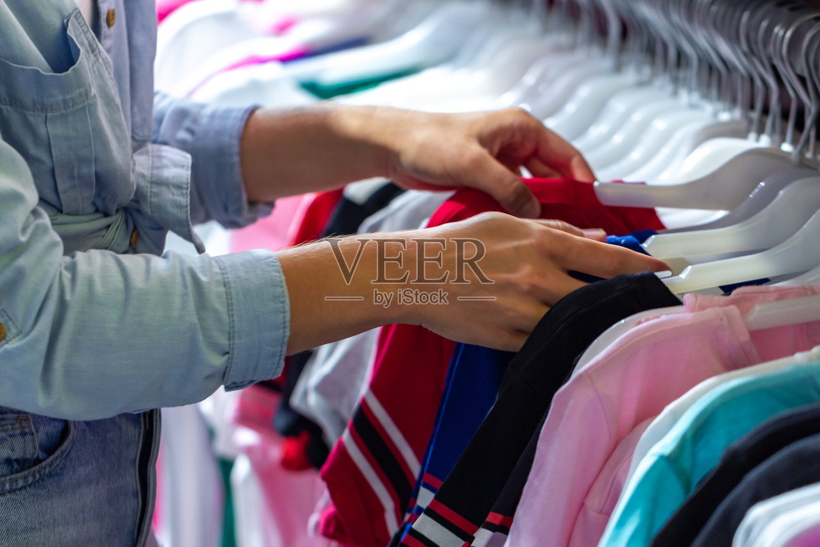 女性在二手市场的商店购买休闲服装。在时尚购物中心购物，为衣橱挑选新衣服。照片摄影图片