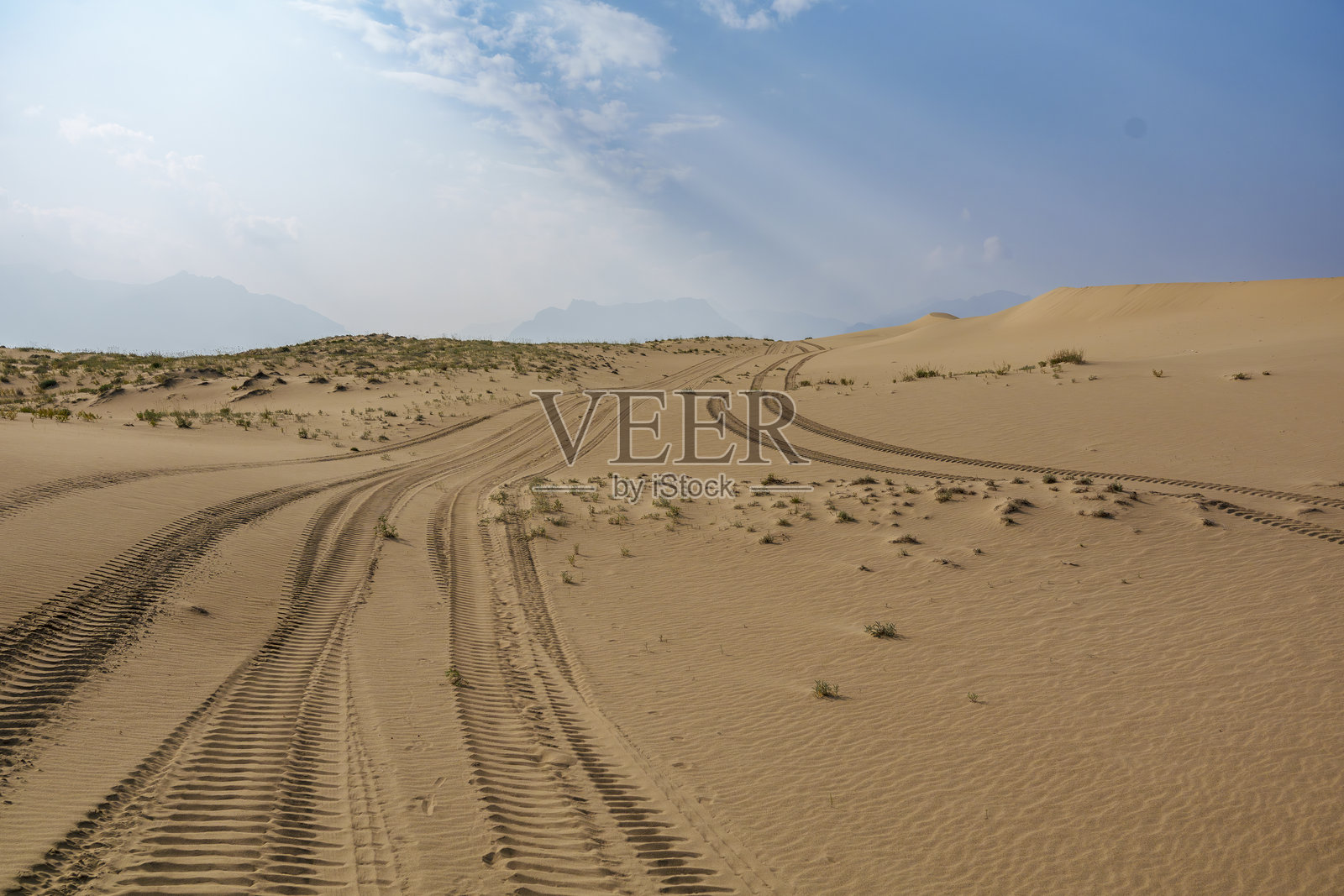 金色沙漠沙丘在戏剧性的天空下被阳光照亮照片摄影图片