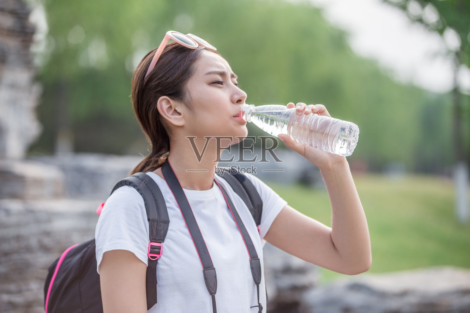 亚洲女性坐在岩石上喝水照片摄影图片