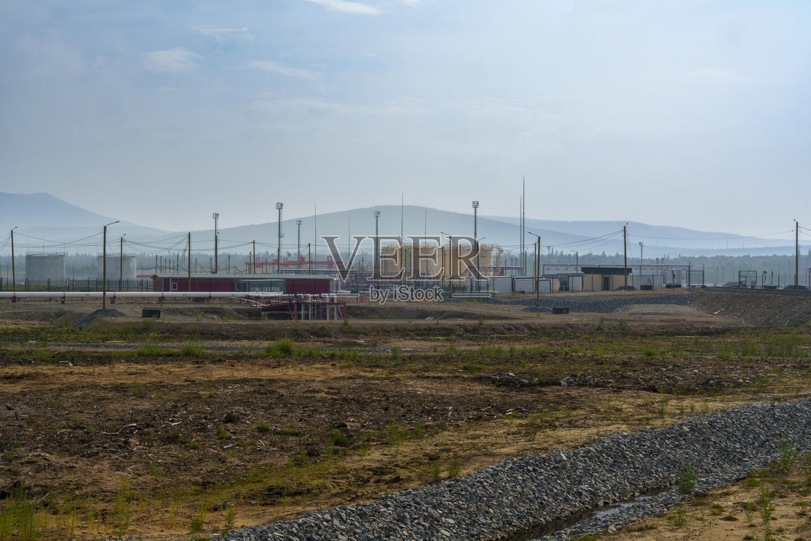 偏远的建筑工地，土路和远处的山脉照片摄影图片