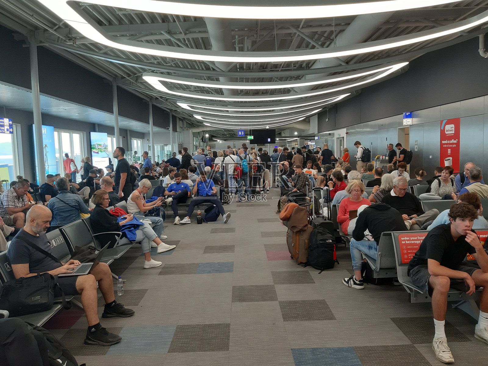 希腊雅典国际机场，乘客们在等待他们的航班照片摄影图片