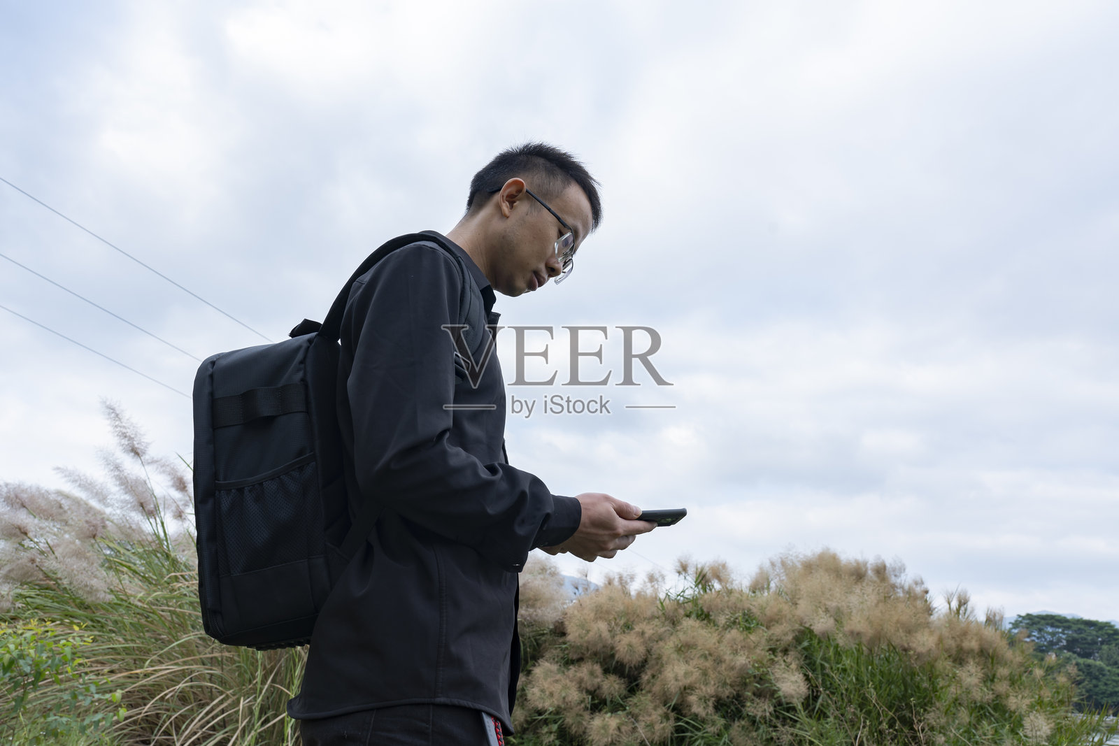 男人们在户外玩手机照片摄影图片