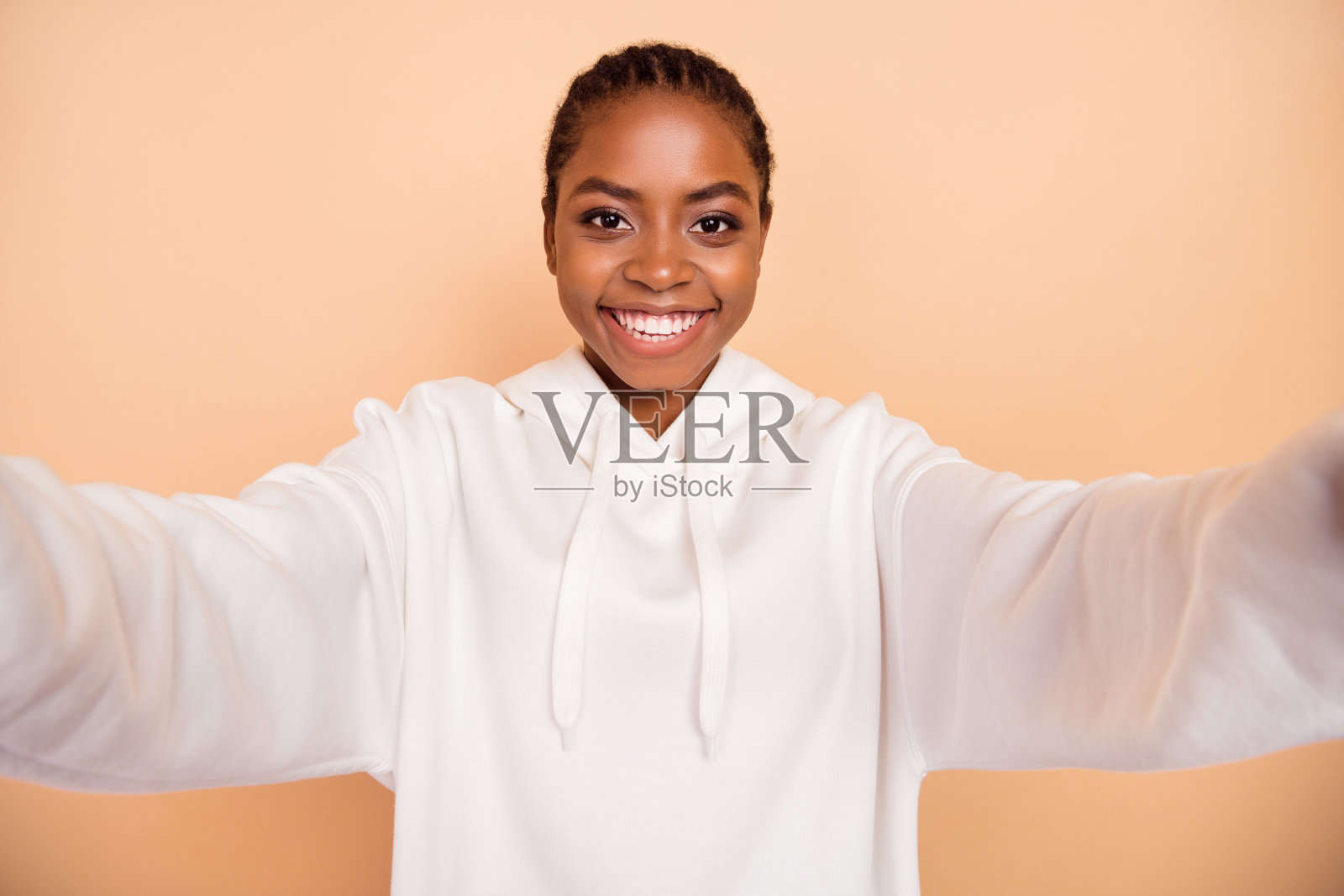 快乐漂亮女孩在米色背景下微笑自拍录制视频照片摄影图片