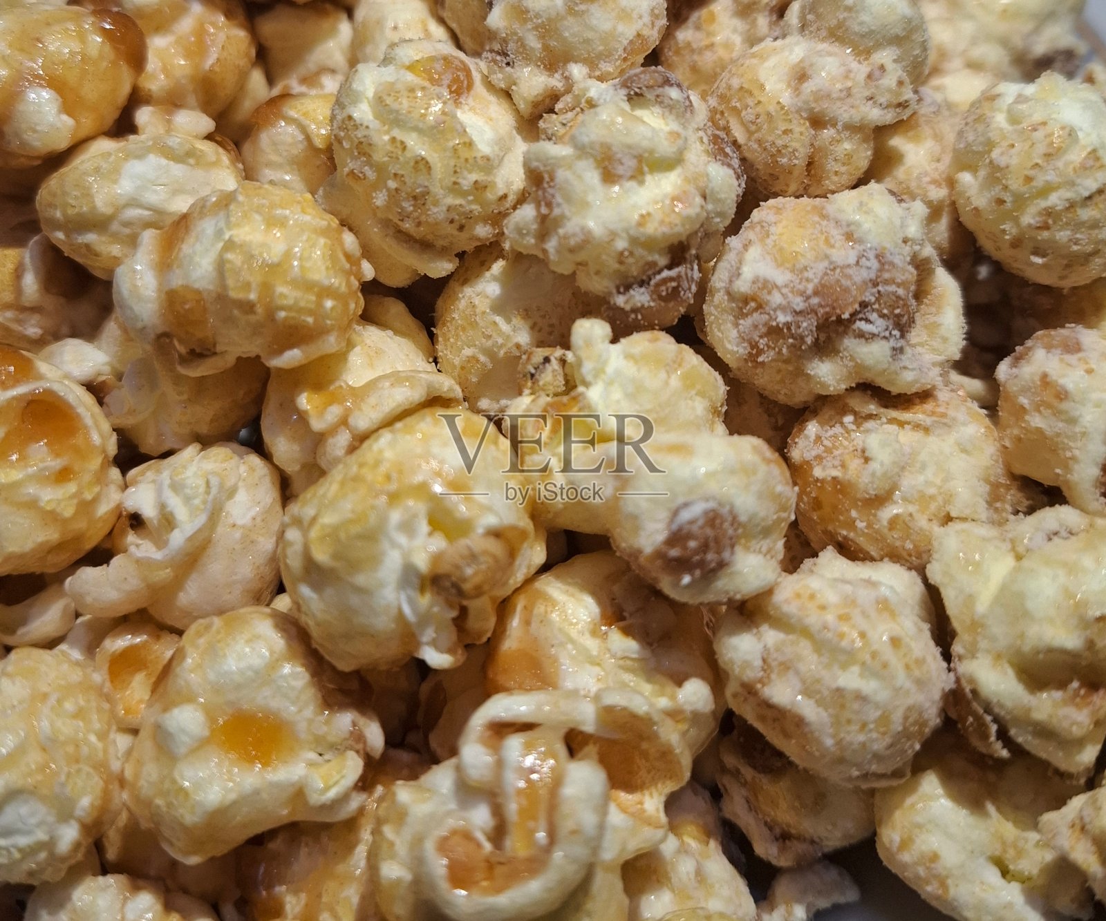 焦糖奶酪黄油爆米花，适合看电影时享用，甜味小吃，由玉米、糖和奶酪黄油制成。照片摄影图片