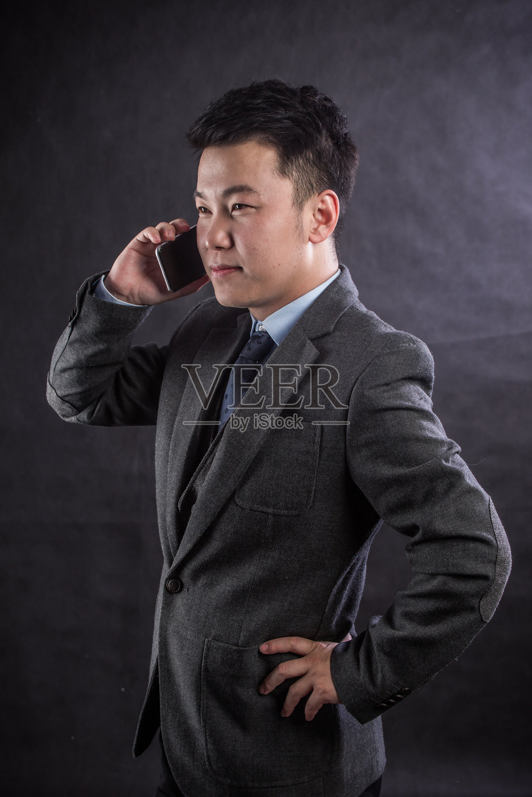 年轻男子靠着墙使用手机的特写镜头照片摄影图片