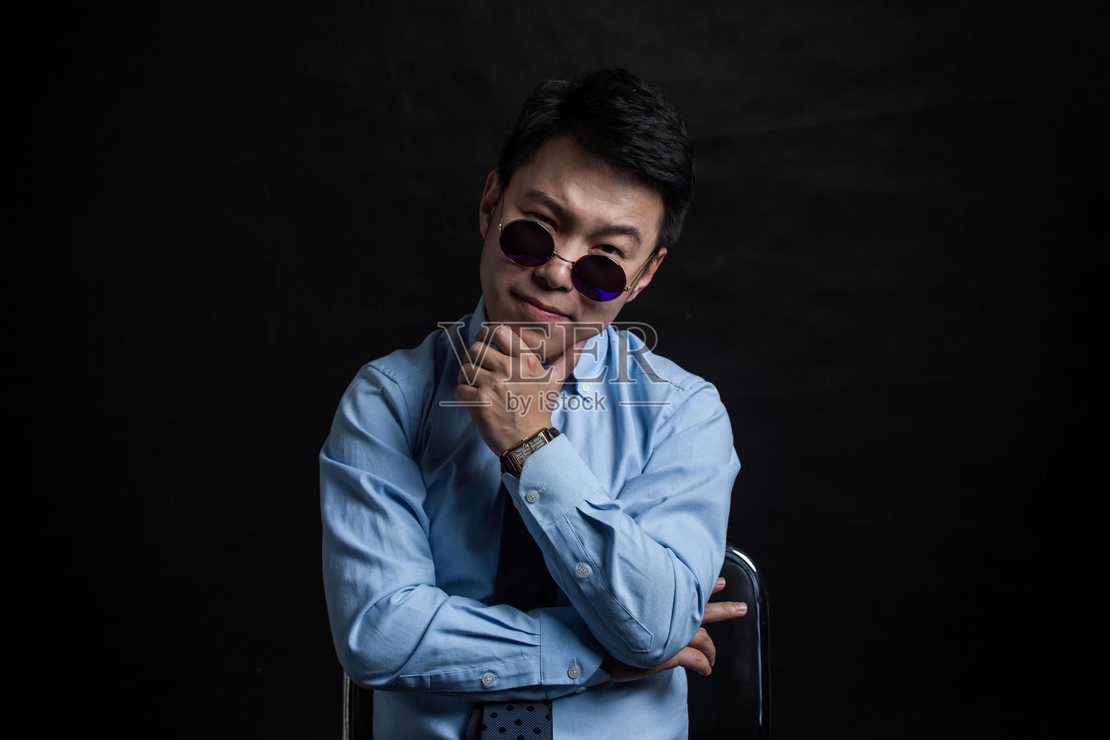 年轻亚洲商人的工作室肖像，佩戴太阳镜照片摄影图片