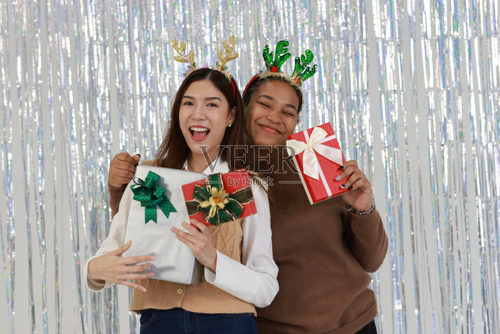 一对情侣在节日期间微笑着手捧圣诞礼物，洋溢着快乐。照片摄影图片