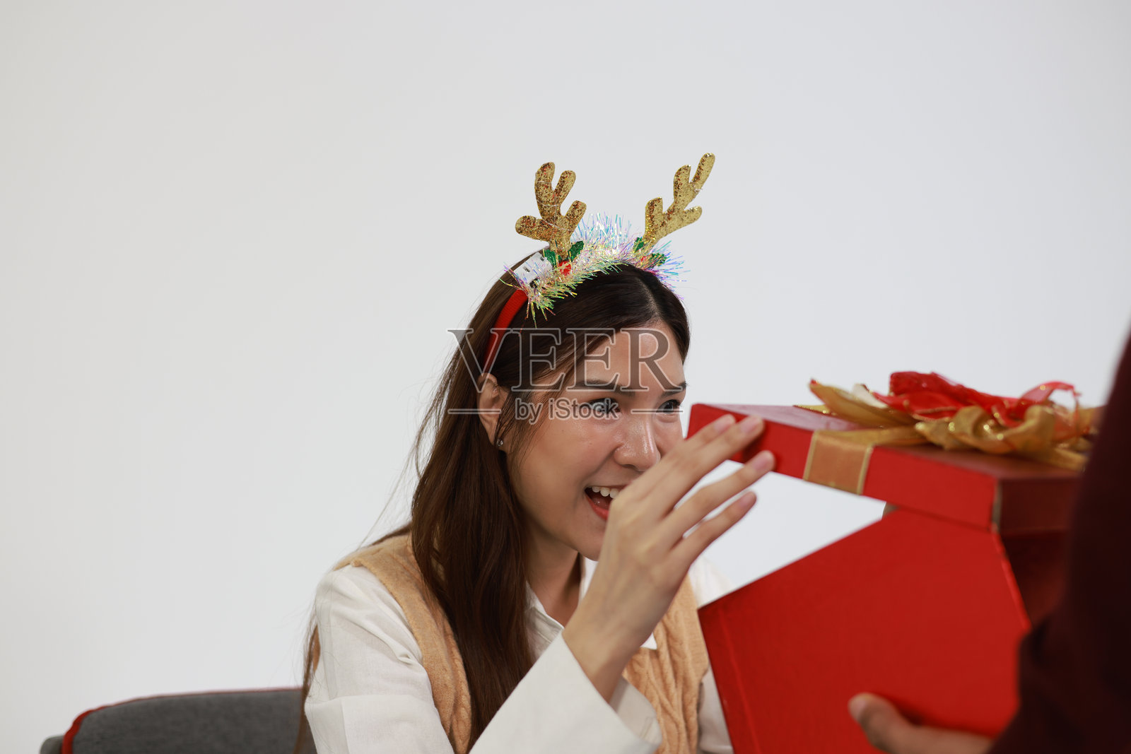 一对情侣在一起庆祝圣诞节，互赠礼物和鲜花，面带微笑，充满爱意，周围洋溢着幸福和浪漫。照片摄影图片