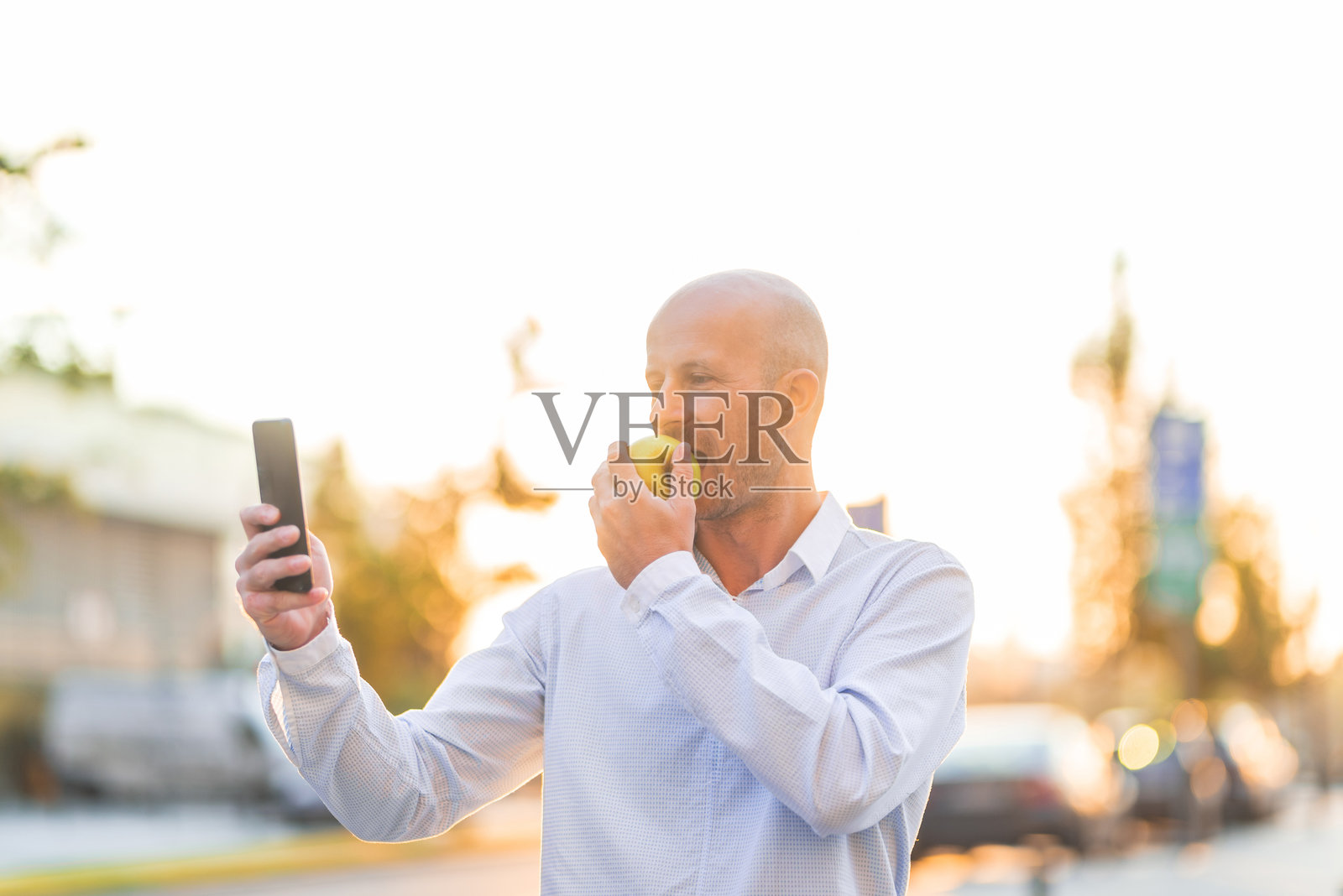 商人在户外吃苹果时自拍照片摄影图片