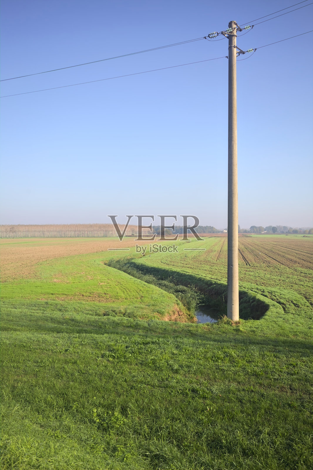 灌溉渠中有水和一个电塔照片摄影图片