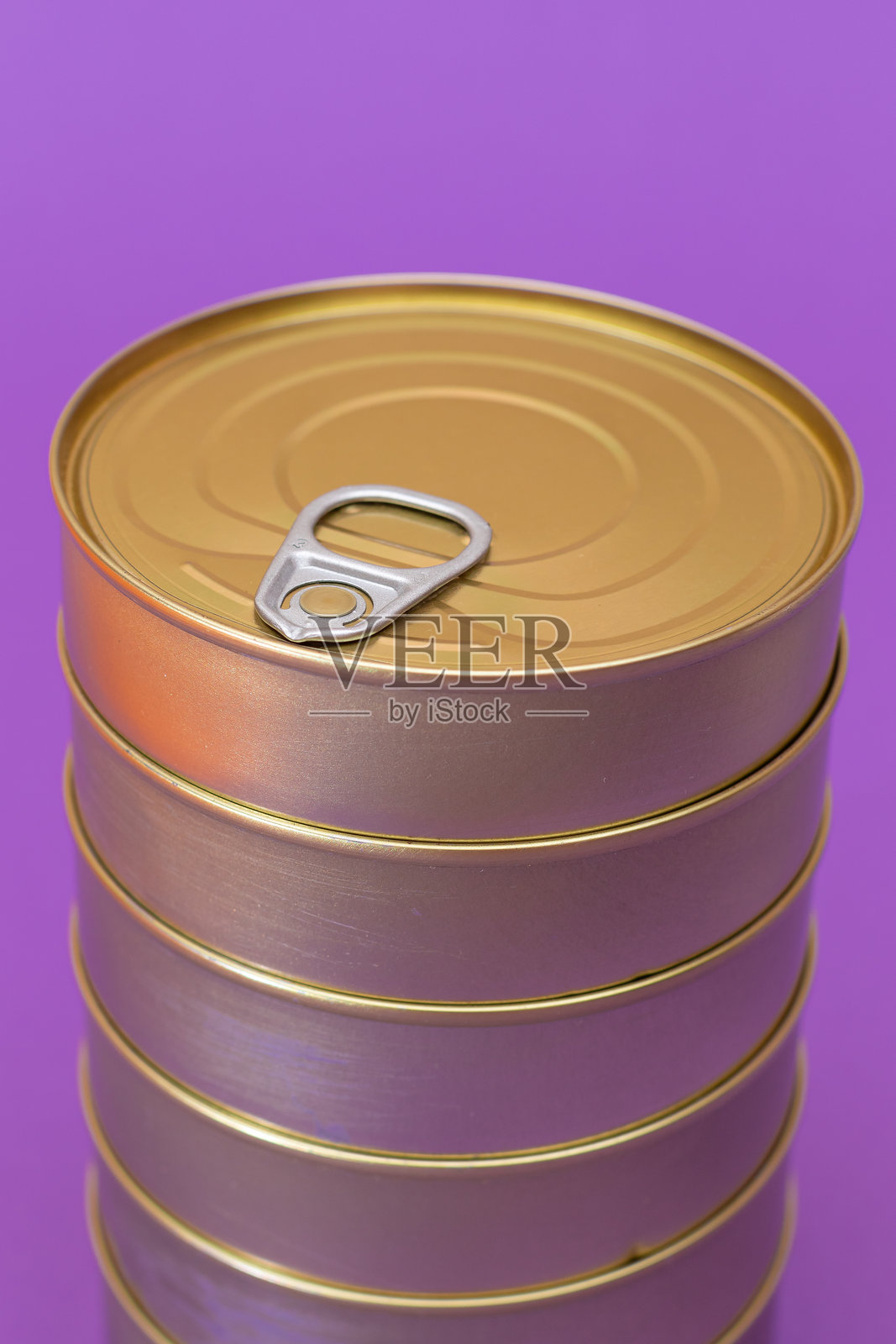 一组叠放的空白边缘锡罐，背景为紫色照片摄影图片