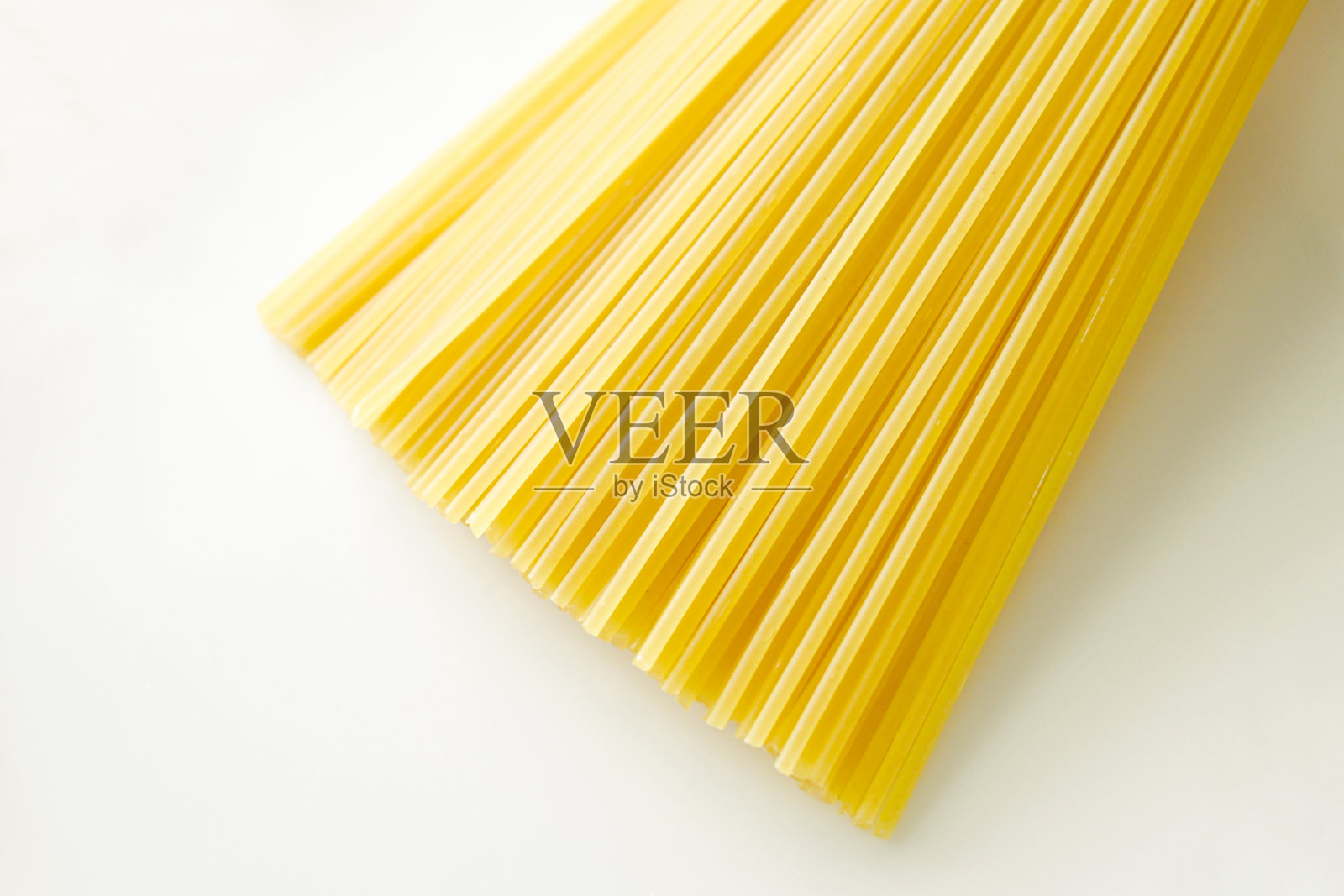 生的意大利面在白色背景上。照片摄影图片