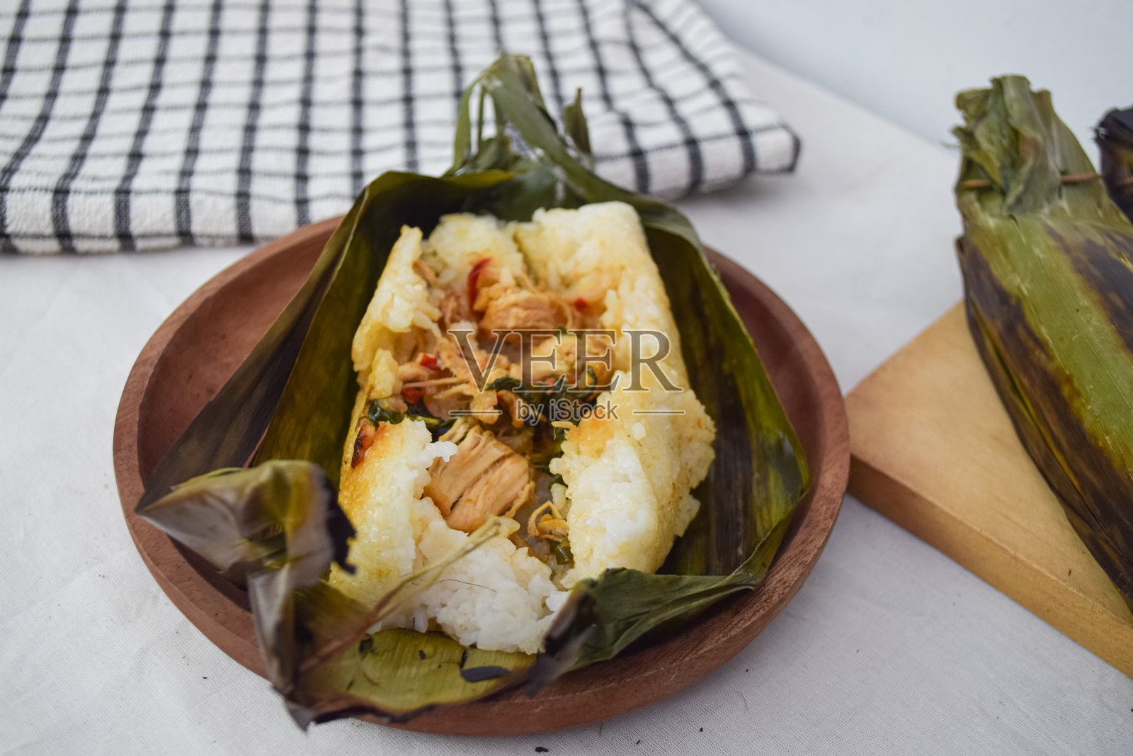 用香草和香料调味的烤米饭，传统印尼美食，展示了一道包裹在香蕉叶中的美味米饭菜肴。照片摄影图片