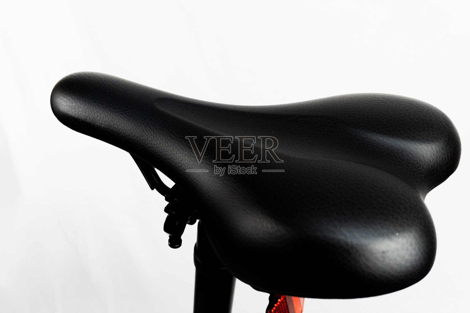黑色舒适的自行车座椅，专为骑行者设计，背景为白色。照片摄影图片