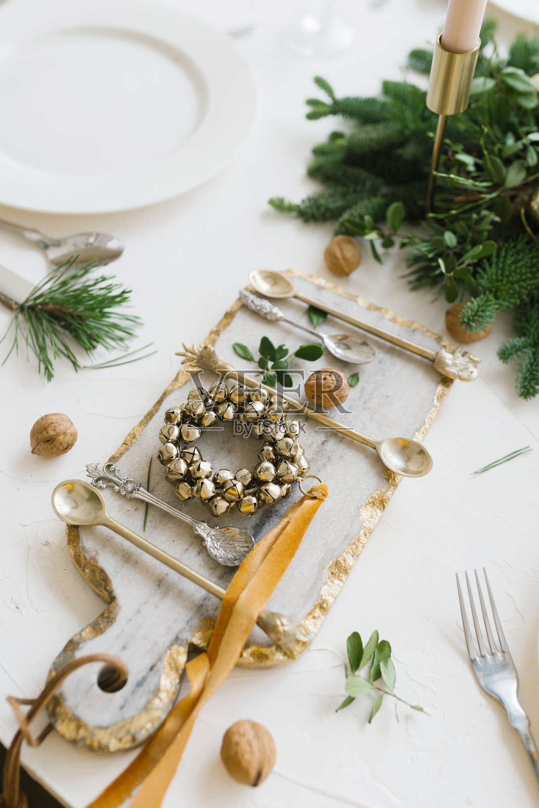 时尚流行的砧板，配有餐具、核桃和铃铛圣诞花环照片摄影图片