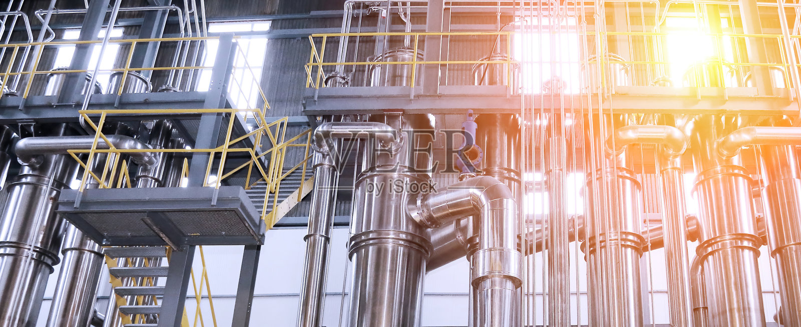 现代化化工处理设施中复杂的管道和容器网络。照片摄影图片